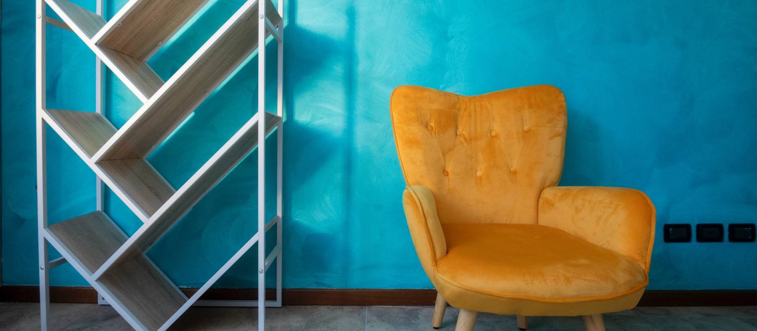 La sala d'attesa di Studio Xenia: parete turchese e poltrona in velluto ocra